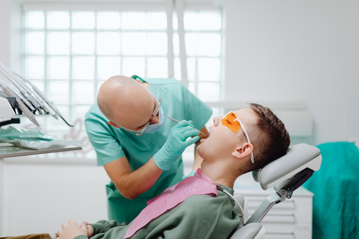 A Dentist Checking a Patient’s Teeth A Dentist Checking a Patient's Teeth