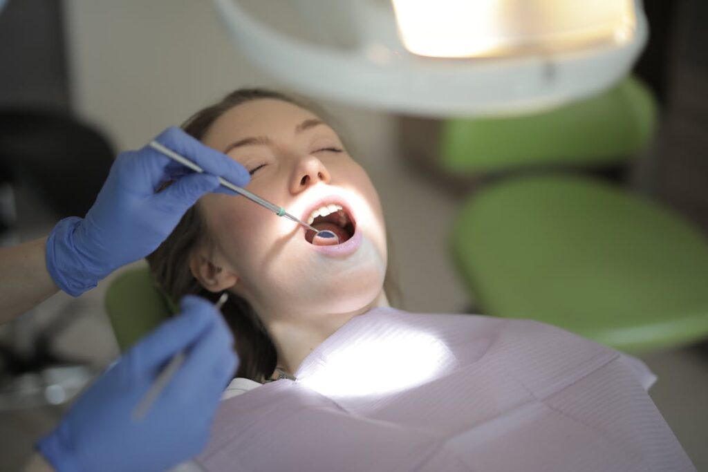 Unrecognizable crop dentist in latex gloves examining teeth