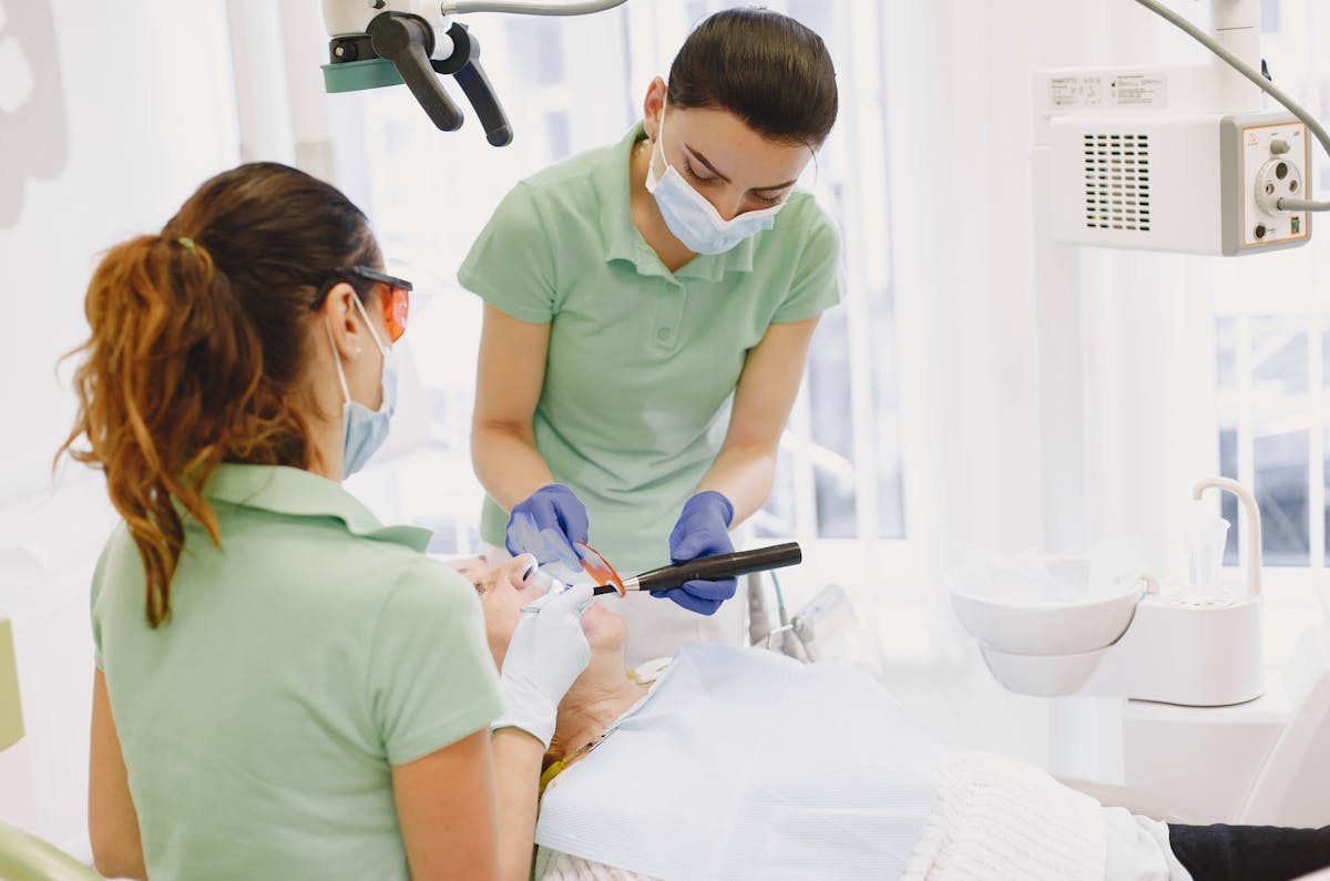 Women Performing Dental Procedures on Patient