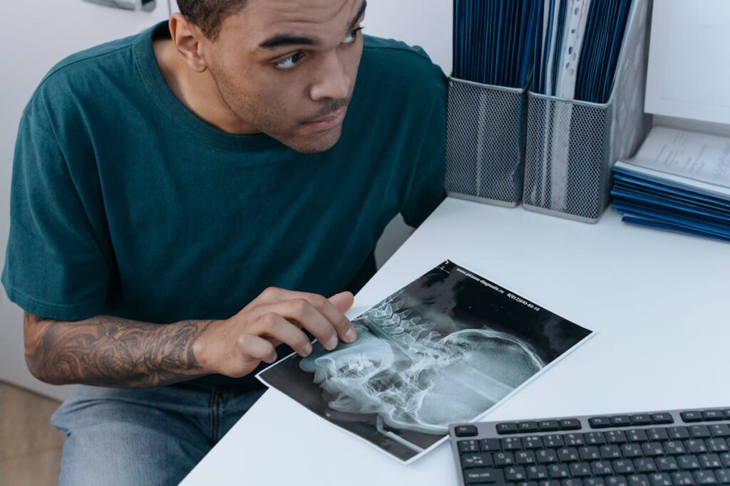 Man looking at a dental x-ray in a clinical setting, focusing on diagnosis.