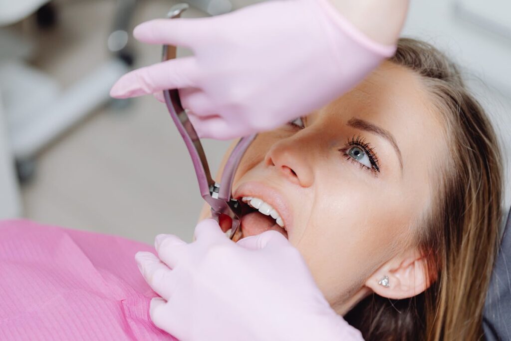 Dentist performing procedure on woman patient using dental tools. Close-up view.