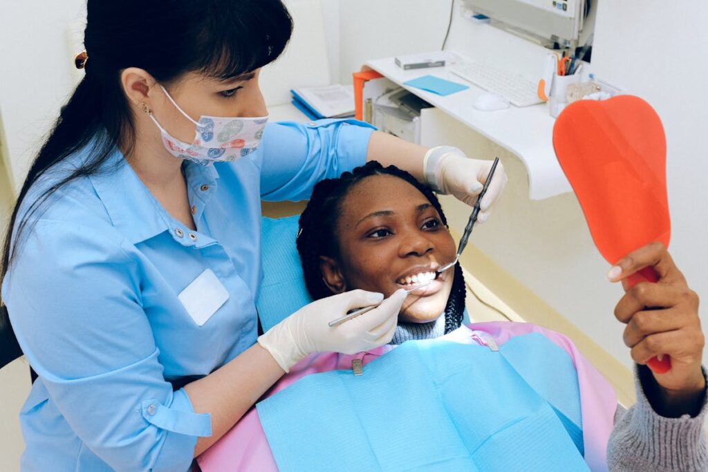A female dentist checks a patient's teeth during a dental appointment.