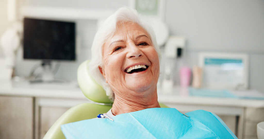 Portrait, smile and senior woman at dentist for teeth whitening results, dentures or oral hygiene. Healthcare, chair and elderly patient in clinic for root canal treatment, dental implants or filling.