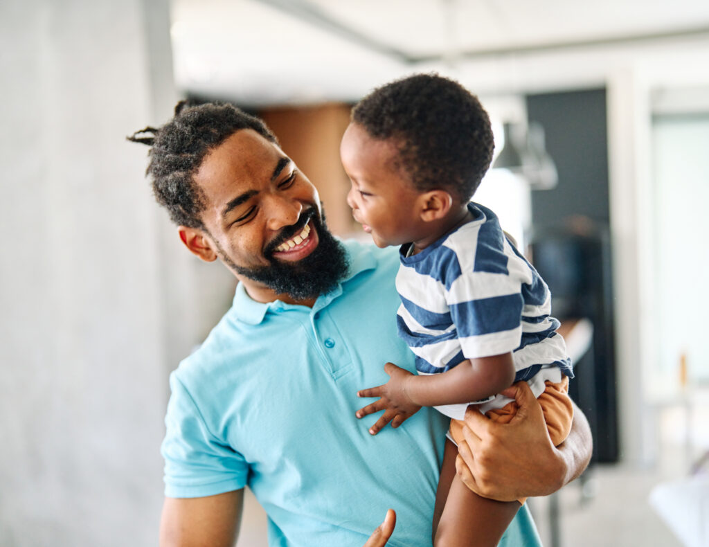 Portrait of father and son having fun at home in bedroom, family life, parenting, love and bonding concepts